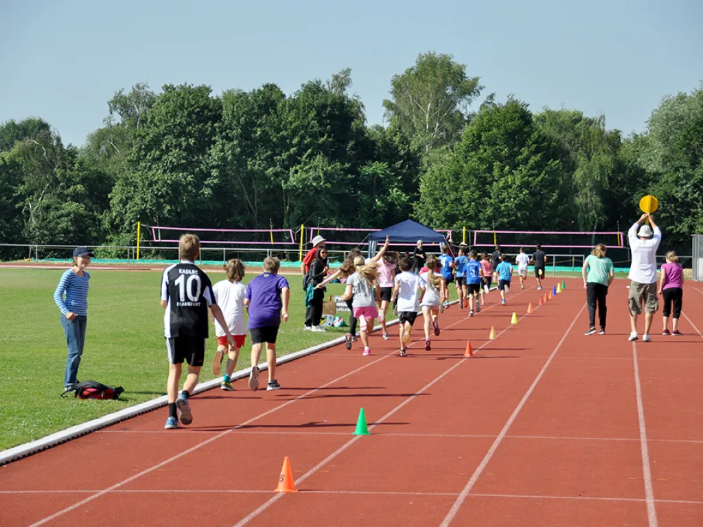 Kinder warten am Start der Laufbahn.